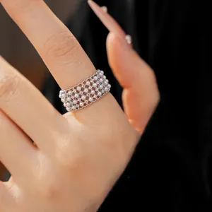Detailed macro view of a multi-layer silver ring with tiny pearls and zircons on a finger
