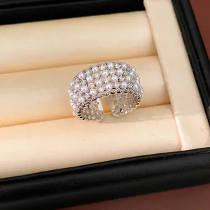 Macro view of multi-layer open ring featuring petite pearls and sparkling zircons