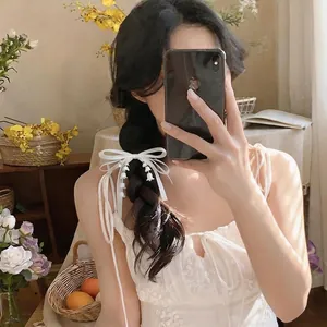 Elegante fermaglio per capelli a fiocco bianco con nappe di mughetto sulla modella