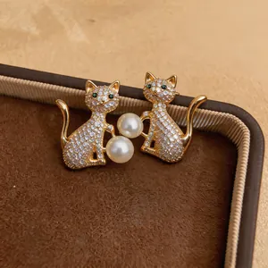 Vue détaillée de boucles d'oreilles chat avec des zircons et des perles élégantes.