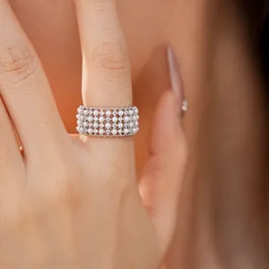 Close-up of multi-layer pearl and zircon ring with a vintage silver grid design.