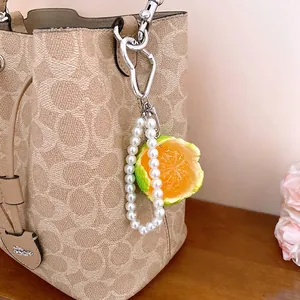 Elegant pearl beaded keychain featuring a realistic half-peeled tangerine fruit charm