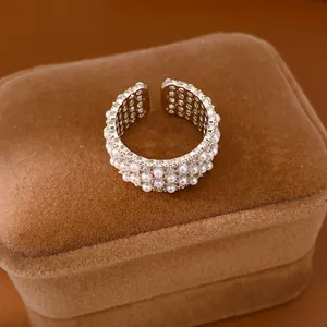 Macro view of a multi-layer pearl and cubic zirconia open ring on a velvet jewelry box