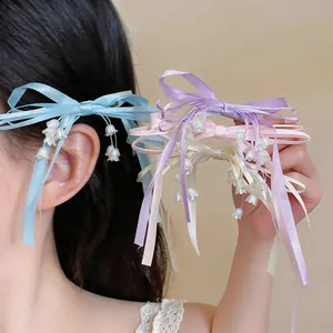 Dettaglio di fermagli per capelli a fiocco con mughetto in vari colori pastello