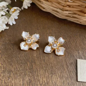 Exquisite French style camellia pearl earrings with sparkling zircon details on wood
