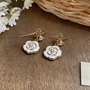 Detailed view of French light luxury camellia and pearl drop earrings with zircons