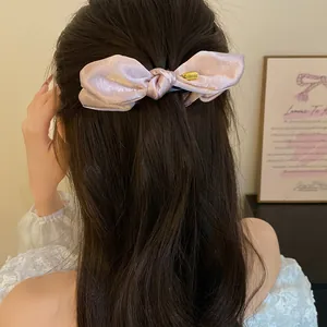 Vue détaillée d'une élégante pince à cheveux banane nœud en satin rose