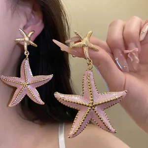 Vintage pink starfish pendant earrings with gold-tone metal finish and silver needle