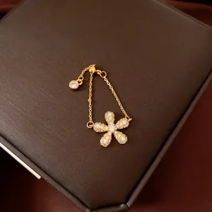 Close-up of a vintage gold chain ring with a crystal flower on a jewelry box.