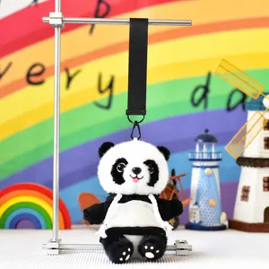 Detailed view of panda plush toy with sweater hanging from a black lanyard