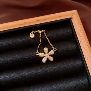 Close-up view of vintage gold flower chain ring with pavé sparkling crystals in a box.