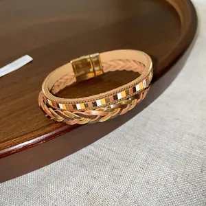 Close-up view detail of Bohemian multi-layer braided leather bracelet with gold clasp