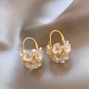 Close-up of French vintage gold flower earrings with crystals on silk background