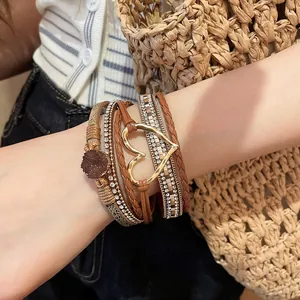Detail view of multi-layer leather bracelet with gold heart charm and rhinestones