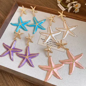 Detailed view of colorful starfish drop earrings with golden trim and enamel finish