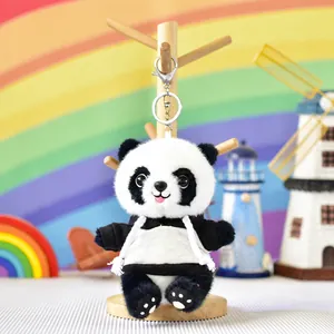 Close-up of a cute plush panda keychain in a black and white hoodie on a wooden display stand.