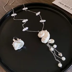 Elegant holiday style pearl and shell necklace with matching ring on black tray