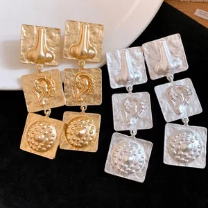 Vintage gold and silver square drop earrings with surrealist nose and ear relief designs