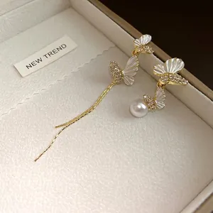 Elegantes pendientes asimétricos de mariposa con pedrería y perla en su estuche
