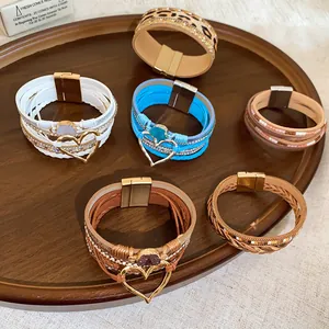 Assorted Bohemian multi-layer leather bracelets with magnetic clasps on a wooden tray