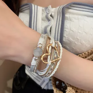 Detail view of a Bohemian layered leather wrap bracelet with a gold heart and magnetic clasp