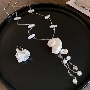 Detail view of seaside style necklace and ring set with pearl and shell pendants