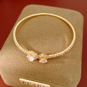 Macro detail of elegant gold-toned heart diamond bracelet presented on a velvet box