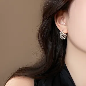 Close-up view of elegant French retro pearl and rhinestone earrings on female model