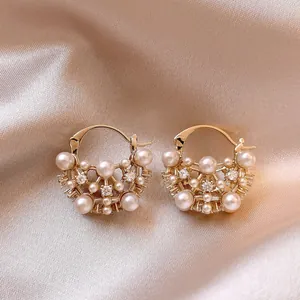 Detailed view of French retro earrings with pearls and rhinestones on silk
