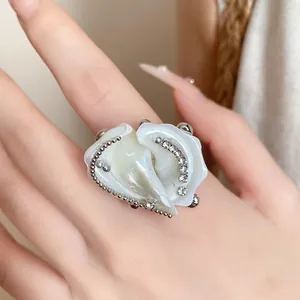 Close-up of a niche design shell conch ring with iridescent finish and rhinestones.