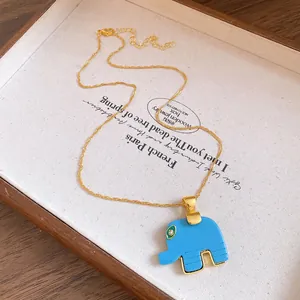 Close-up of bohemian blue resin elephant pendant necklace on a wooden display tray