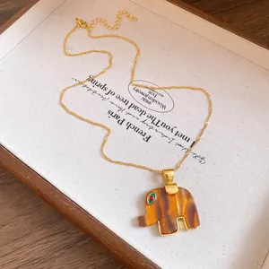 Detailed view of the vintage amber resin elephant pendant with golden trim and eye