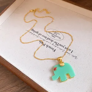 Detailed view of bohemian green resin elephant pendant on a dainty gold-toned chain necklace