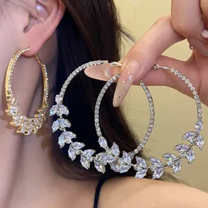 Detail of sparkling cubic zirconia wheat ear hoop earrings with silver pins.