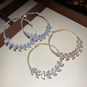 Close-up of elegant zircon wheat ear hoop earrings in gold and silver finishes