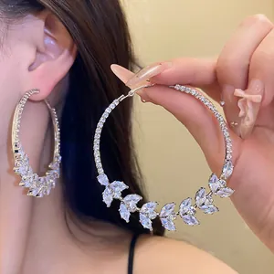 Close-up of silver-tone hoop earrings featuring a sparkling zircon wheat ear design