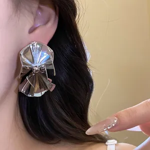 Elegant vintage minimalist silver-plated pleated stud earrings shown on an elegant model