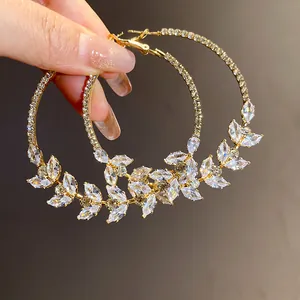 Detailed view of gold-tone wheat ear hoop earrings with sparkling cubic zirconia