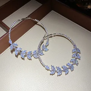 Detailed macro view of silver hoop earrings with marquise-cut zircon wheat ear design