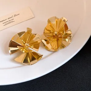 Macro view of elegant gold-plated flower petal stud earrings featuring a high-gloss finish.