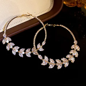 Detailed view of gold hoop earrings featuring marquise cubic zirconia wheat ear design