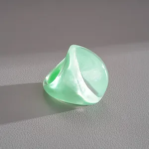 Close-up detail of a chunky mint green resin fan ring showing pearlescent texture and shape