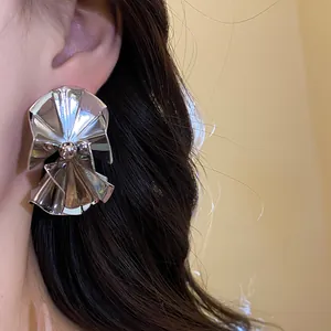 Detailed close-up showing the high-shine metallic texture of silver pleated fan earrings