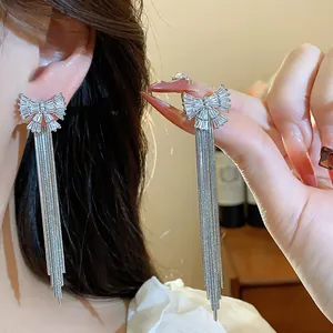 Boucles d'oreilles nœud en zircon avec longues franges argentées sur un mannequin