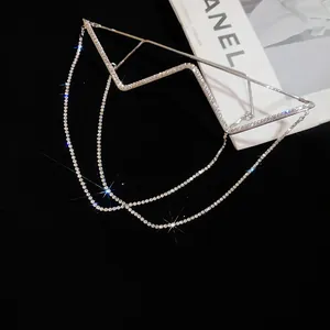 Detailed shot of a silver W-shaped decorative eyewear frame featuring rhinestone tassels