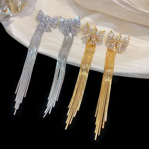 Élégantes boucles d'oreilles nœud plaquées or 18 carats avec longs glands en zircon.