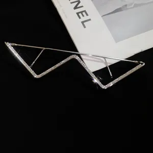 Detail view of a luxury rhinestone encrusted W-shaped decorative eyewear frame without lenses