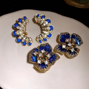 Vintage gold-tone floral and fan-shaped stud earrings with blue stones and crystals.