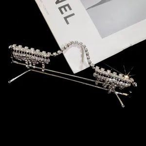 Macro detail view of silver W-shaped eyewear frame with sparkling rhinestone tassels