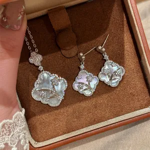 Close-up view of white mother-of-pearl window flower necklace and earring set in box